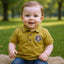 Child wearing a mustard yellow polo shirt with a logo.