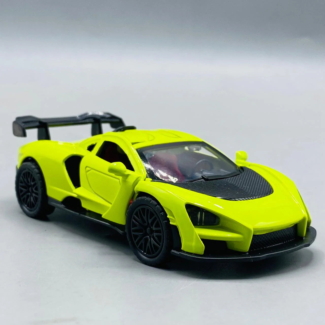 Yellow die-cast sports car model on a gray background