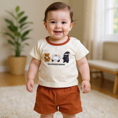 Child wearing a white shirt with graphics and brown shorts.