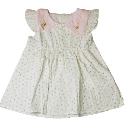 White dress with pink trim and floral pattern on a white background