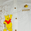 Baby romper with Winnie the Pooh design on a white background