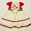 Children's dress with red and white lace details on a light gray background