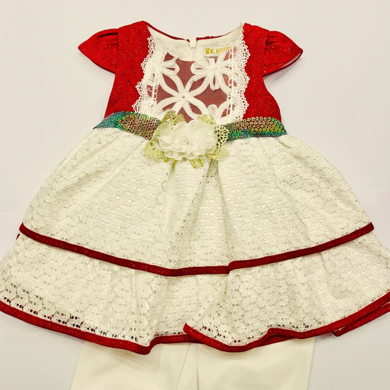 Children's dress with red and white lace details on a light gray background