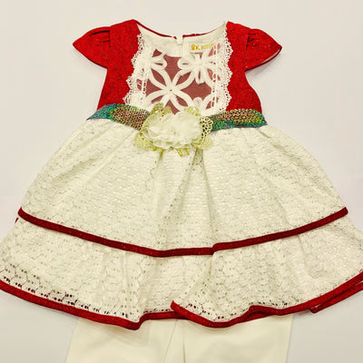 Children's dress with red and white lace details on a light gray background
