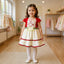 Young girl in a red and white dress standing in a clothing store.