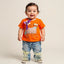 Child wearing an orange shirt with a bow and blue jeans 